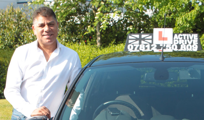 Ram, owner and driving instructor at Active Drive, standing beside the branded Active Drive car
